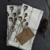 Pair of unbleached cotton napkins on slate with poppy head design