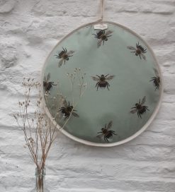 Bee aga lid cover hanging on white wall