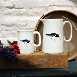 Two sized jugs featuring the Oystercatcher design with flowers