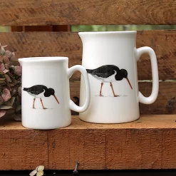 Two Oystercatcher jugs with flower