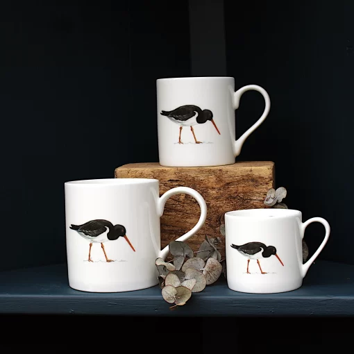 Three Oystercatcher mugs with leaves on shelf